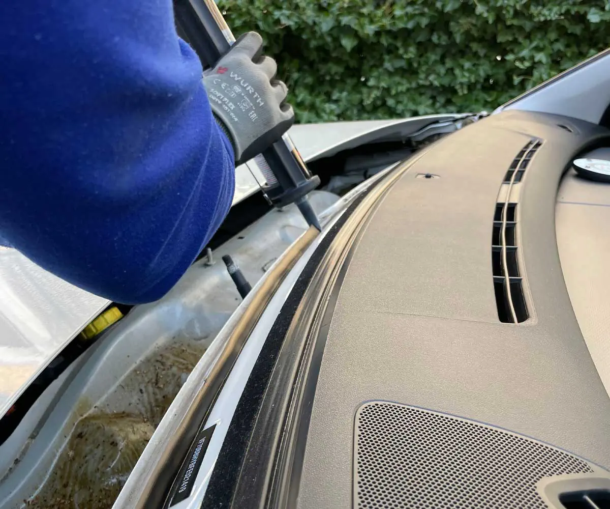 Automotive windshield adhesive being applied during professional glass installation